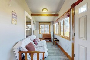 A hallway with a wooden bench, a sofa, and a small table. - Home with washer/dryer, gas grill, & outdoor dining - walk 5 minutes to beach (Rockport)