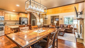 Una cocina amplia con armarios de madera, un comedor con una mesa grande y una sala de estar acogedora con chimenea.