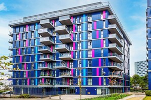 En bygning med flere etager, altaner, store vinduer og moderne arkitektur.