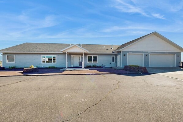 A single-story house with a garage, a front porch, and a driveway. - Spacious home with pool table, WiFi, patio - close proximity to Flathead Lake (Kalispell)