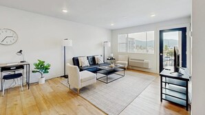 Una sala de estar moderna con sofá, mesa de centro y escritorio.