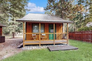A wooden cabin with a porch, a green door, and a metal roof. - Enjoy two separate cabins, pet friendly, firepit, 5 min to Lake, fly-fishing (Bigfork)