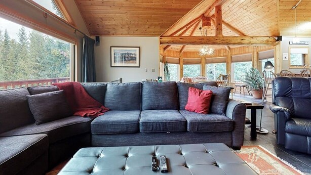 Ein gemütliches Wohnzimmer mit einer großen Couch, einem Couchtisch und einem Kamin.