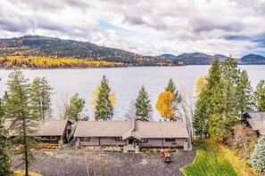 Eine Lodge am See mit Blockhütten, einem Parkplatz und Blick auf See und Berge.