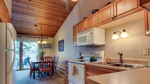 Una cucina con mobili in legno, un forno a microonde, un piano cottura e un lavello.