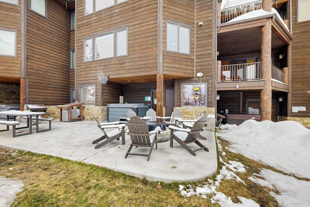 Un immeuble à plusieurs étages doté d’un patio comprenant un espace extérieur avec des sièges et un barbecue.