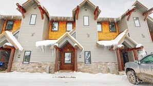 A multi-story building with a symmetrical facade, multiple windows, and a snow-covered ground.
