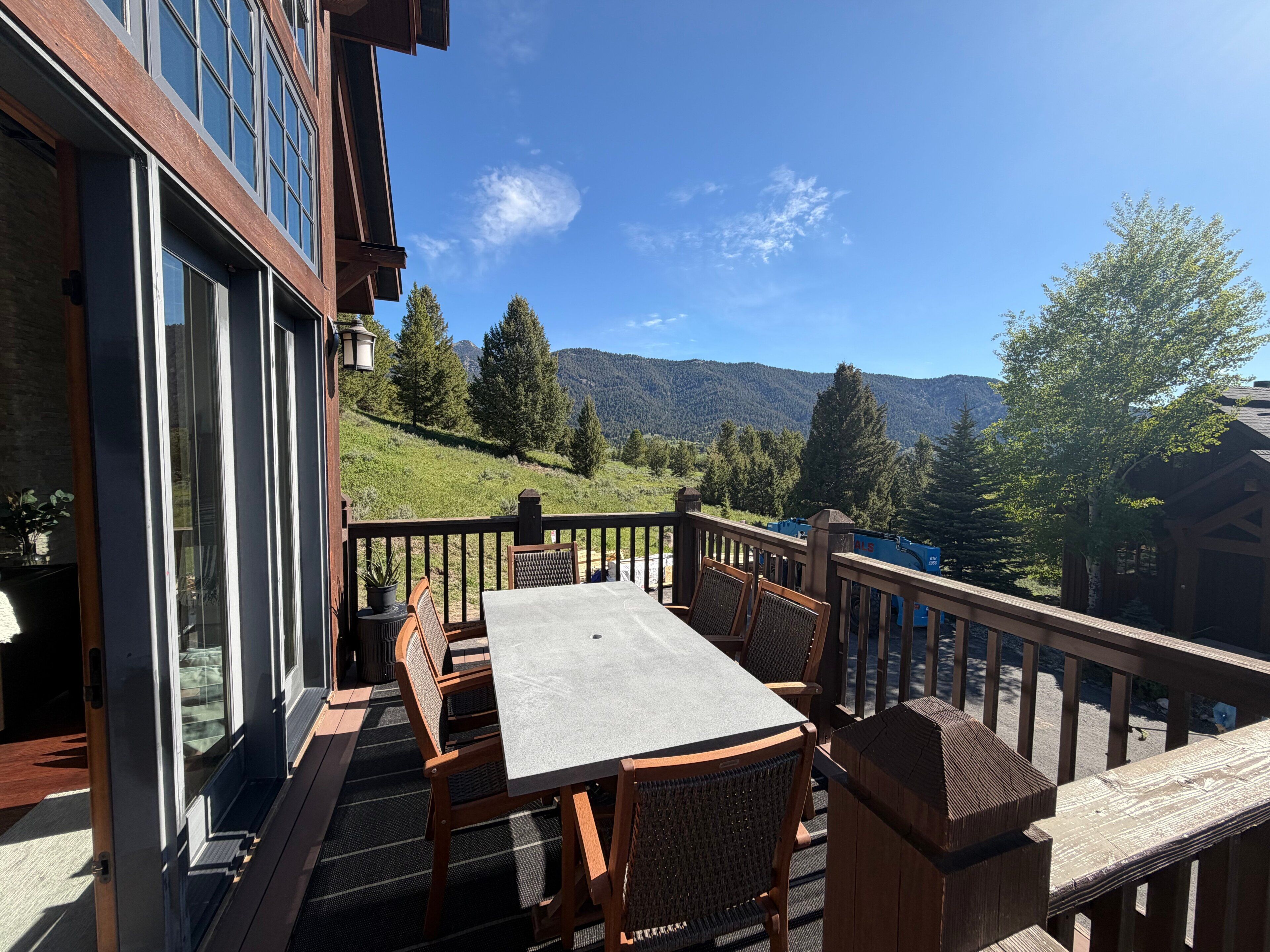 Un balcon avec une table et des chaises, donnant sur un paysage montagneux.