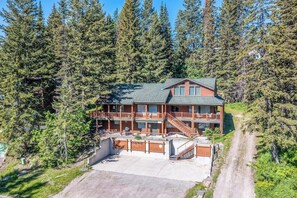 Eine zweistöckige Lodge mit Balkon, umgeben von dichtem Wald.