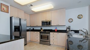 Eine moderne Küche mit Kühlschrank, Mikrowelle, Herd und Spüle.