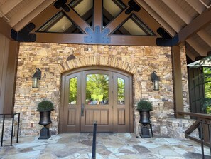 A stone entrance with a wooden door, two potted plants, and a stone floor. - Golf + Fishing + Boating, Perfect 2 bedroom + Loft in Big Canoe, Sleeps 6-8 (Jasper)
