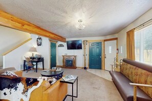 Ein Wohnzimmer mit Kamin, Fernseher und einer Couch.