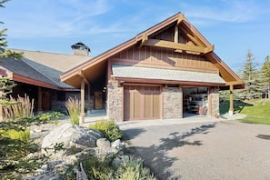 Ein zweistöckiges Haus mit Steinverkleidung, einer Garage und einer überdachten Veranda.