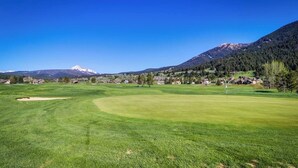 Un campo de golf con vista despejada a una montaña al fondo.