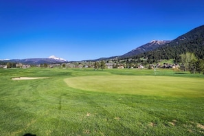Ein Golfplatz mit freiem Blick auf einen Berg im Hintergrund.