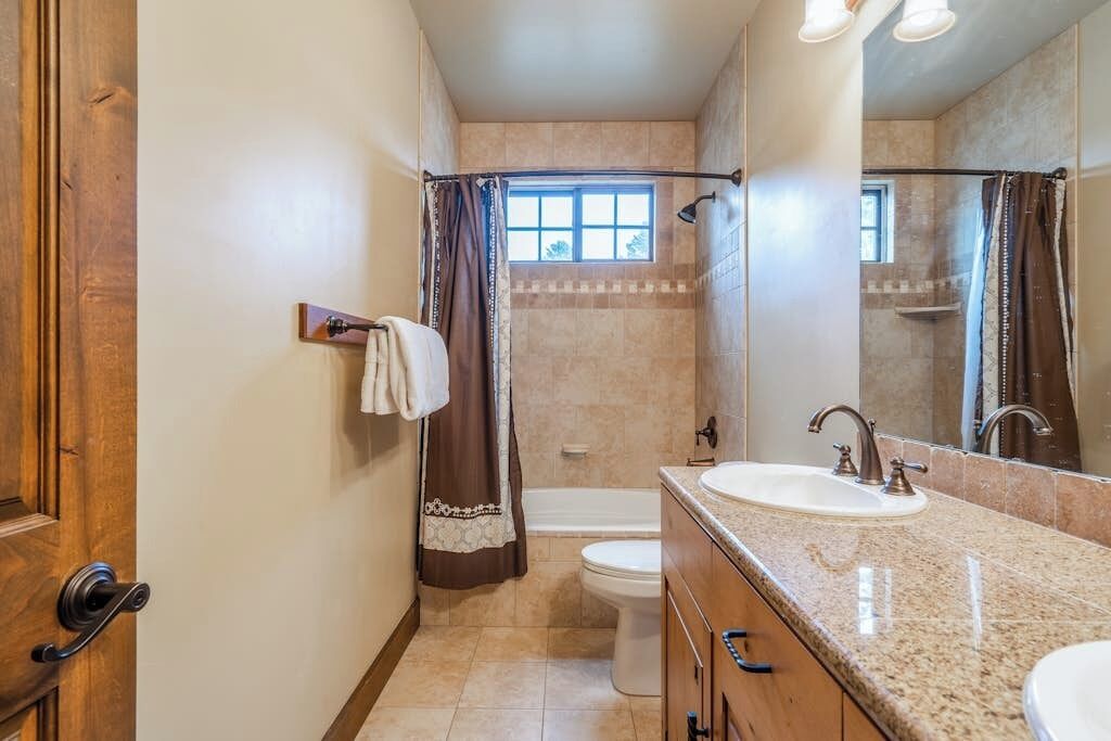 Ein Badezimmer mit Badewanne, Toilette, Waschbecken und Spiegel.