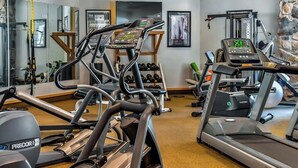 Un gimnasio con cintas de correr, pesas y equipo de ejercicio.