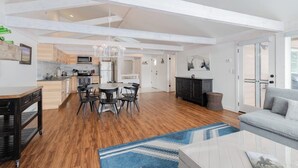A spacious living area with a kitchen, dining table, and a fireplace. - Beautiful, modern townhome next to the golf course with WiFi and full kitchen (Jackson)