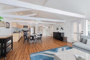 A spacious living area with a kitchen, dining table, and a fireplace.