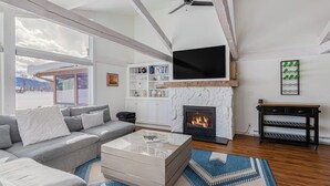 A living room with a fireplace, a sofa, a coffee table, and a television. - Beautiful, modern townhome next to the golf course with WiFi and full kitchen (Jackson)