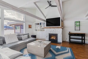 A living room with a fireplace, a sofa, a coffee table, and a television.