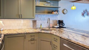 A kitchen with a granite countertop, stainless steel appliances, and a clock on the wall. - Gorgeous country escape with deck & wood-burning fireplace -  near hiking trails (Jackson)