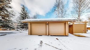 A two-car garage with a snow-covered roof, surrounded by trees and a clear sky. - Gorgeous country escape with deck & wood-burning fireplace -  near hiking trails (Jackson)