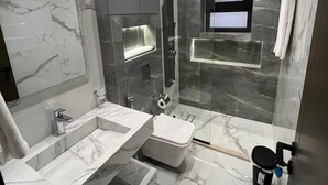 Un baño moderno con dos lavamanos, ducha y retrete.