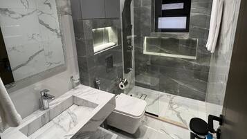 Separate bathtub and shower, towels, soap, shampoo