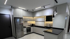 Una cocina moderna con una isla central, electrodomésticos de acero inoxidable e iluminación empotrada.