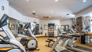 Ein Fitnessstudio mit Laufbändern, Crosstrainern und Gewichten.