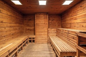 Un sauna en bois, doté de bancs et de lucarnes.
