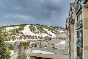 Ein Skigebiet mit Holzhütten, einem Hotel und einem Berg im Hintergrund.