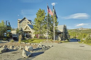 Ein Gebäude mit einer großen amerikanischen Flagge, einem Berg im Hintergrund und einem gepflegten Rasen.