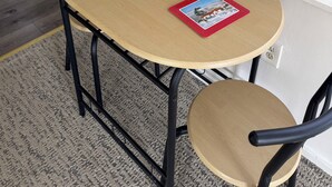 Una mesa redonda con dos sillas, una planta pequeña en maceta y dos caminos rojos con imágenes.