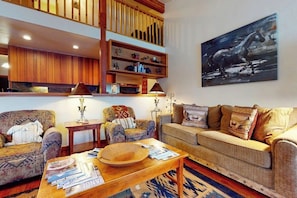 A living room with a sofa, armchairs, a coffee table, and a bookshelf. - Lovely home with well-equipped kitchen & back deck - walk to shopping & dining (Wilson)
