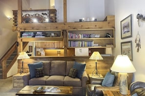 Ein gemütliches Wohnzimmer mit Sofa, Couchtisch und Bücherregalen.