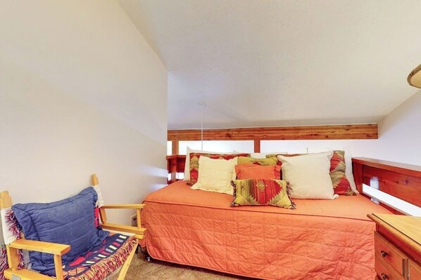 A bedroom with a bed, a wooden chair, and a wooden headboard. - Berry Patch retreat steps from Fish Creek between Jackson and the Village (Wilson)