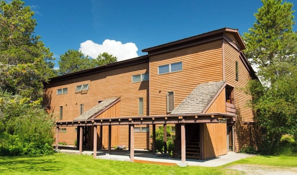 A two-story wooden building with a covered porch and a small annex.