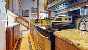 A kitchen with wooden cabinets, a stainless steel stove, granite countertops, and a built-in oven. - Beautiful country home with full kitchen & views from the private balcony (Wilson)