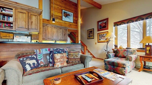 A cozy living room with a sofa, coffee table, and a fireplace. - Beautiful country home with full kitchen & views from the private balcony (Wilson)