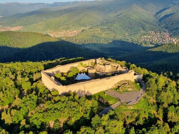 A fortified structure surrounded by dense forest, with a clear view of the surrounding landscape.
