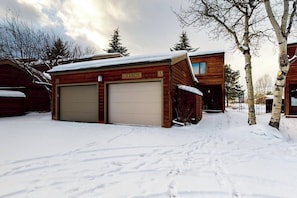 Ein Holzhaus mit Garage, auf der 'GRANITE' steht, und verschneietem Gelände.