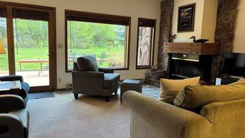 A living room with a fireplace, a sofa, a chair, and a television.