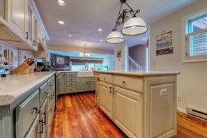 A kitchen with wooden flooring, light-colored cabinets, and pendant lighting. - Welcoming, well-equipped condo with furnished deck, jetted tub & fireplace (Jackson)