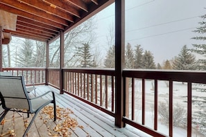 Eine Holzdielen-Terrasse mit Blick auf eine verschneite Landschaft.