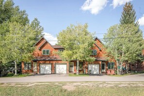 Ein zweistöckiges Haus mit Garage, Veranda und Auffahrt.