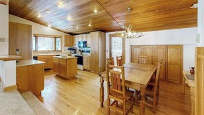 Un'ampia cucina con mobili in legno, un tavolo da pranzo e un lampadario.