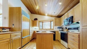Una cucina con mobili in legno, un'isola centrale e un piano cottura.