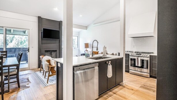 A modern kitchen with a central island, built-in oven, and a flat-screen TV. - Gorgeous, modern mountain view condo with deck & great kitchen (Wilson)